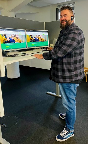 Philipp Reske mit Headset an seinem Arbeitsplatz in der Kundenberatung der AOK Rheinland/Hamburg.